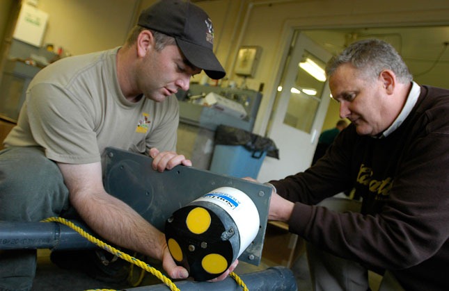 Fisheries Biologist Travis Hartman works with a NexSens field engineer to mount an acoustic Doppler current meter.