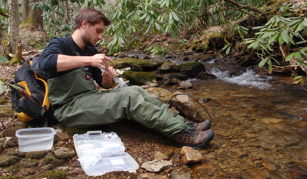 Kyle Dost collects water samples for analysis of total dissolved solids. (Credit: Anthony Timpano)