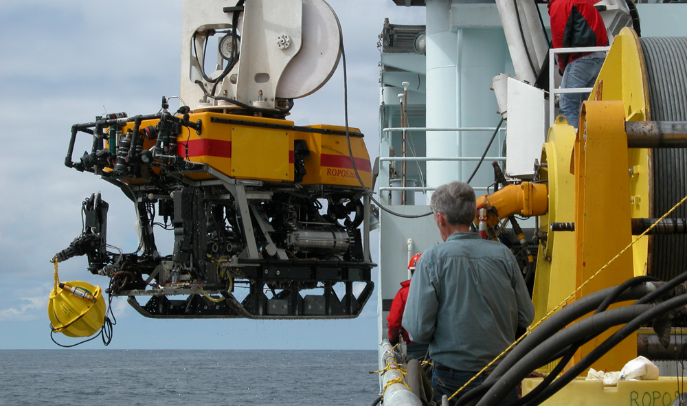 The remotely operated vehicle ROPOS being recovered by the R/V Thomas G. Thompson with a short period seismometer package developed by the Monterey Bay Aquarium Research Institute held by the manipulator arm.  (Credit: Mitchell Elend, UW)