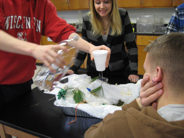 Students observing runoff in a watershed model to give students a 3D sense of what a watershed is and how surface runoff can move material and contaminants. (Credit: Tarin Weiss)