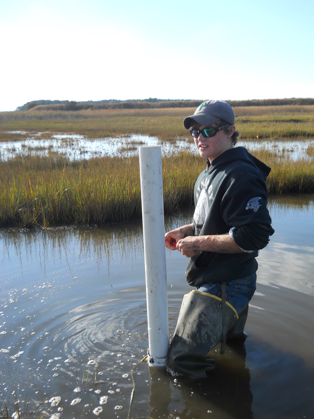 Shippensburg University student with installed monitoring well (Credit: Chincoteague Bay Field Station)