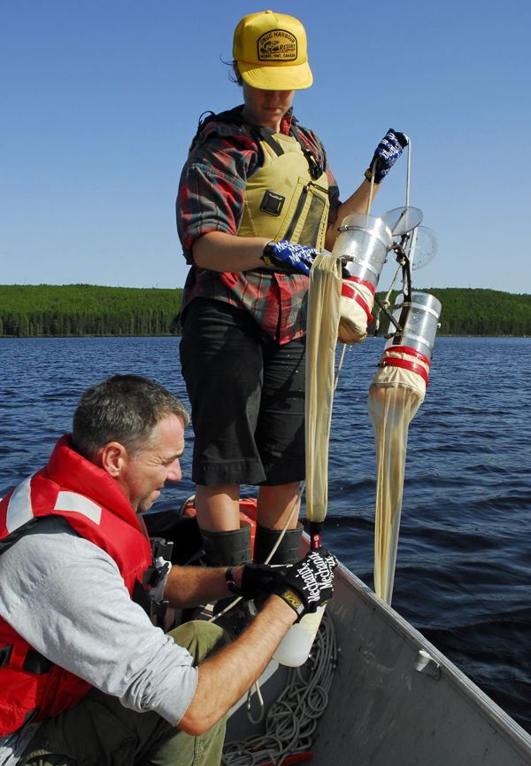 Technician Ken Sandilands and a student assistant sampling zooplankton using a double-barrelled net sampler.  All key components of the ecosystem are monitored, both in manipulated systems and in nearby natural reference systems.