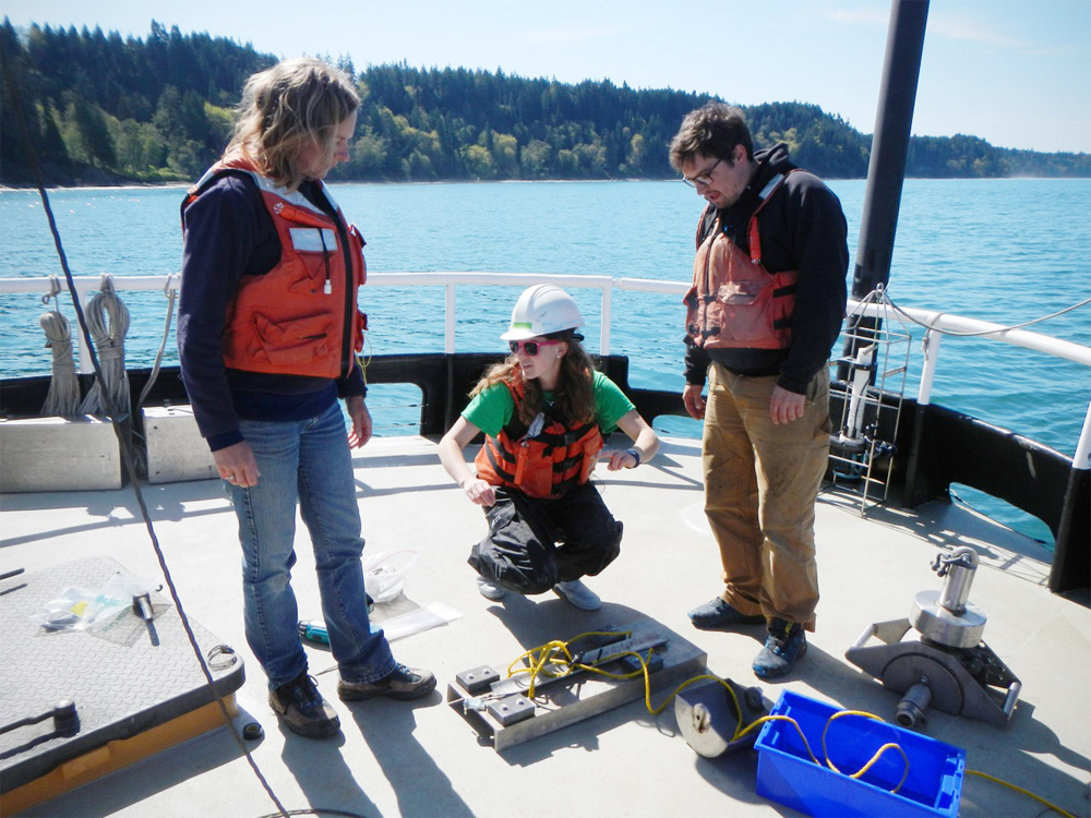 Students and faculty discuss the deployment of a short term mooring to study the attenuation of light reaching the seabed due to sediment in the Elwha River plume. (Credit: Emily Eidam)
