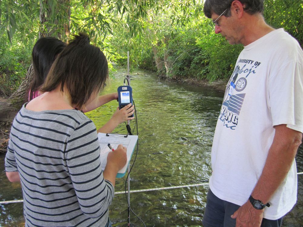 Stream Team volunteer Mark Story teaches students with Big Sky Youth Empowerment to measure discharge with an OTT Flow Meter on Bozeman Creek. (Credit: Katherine Boyk)