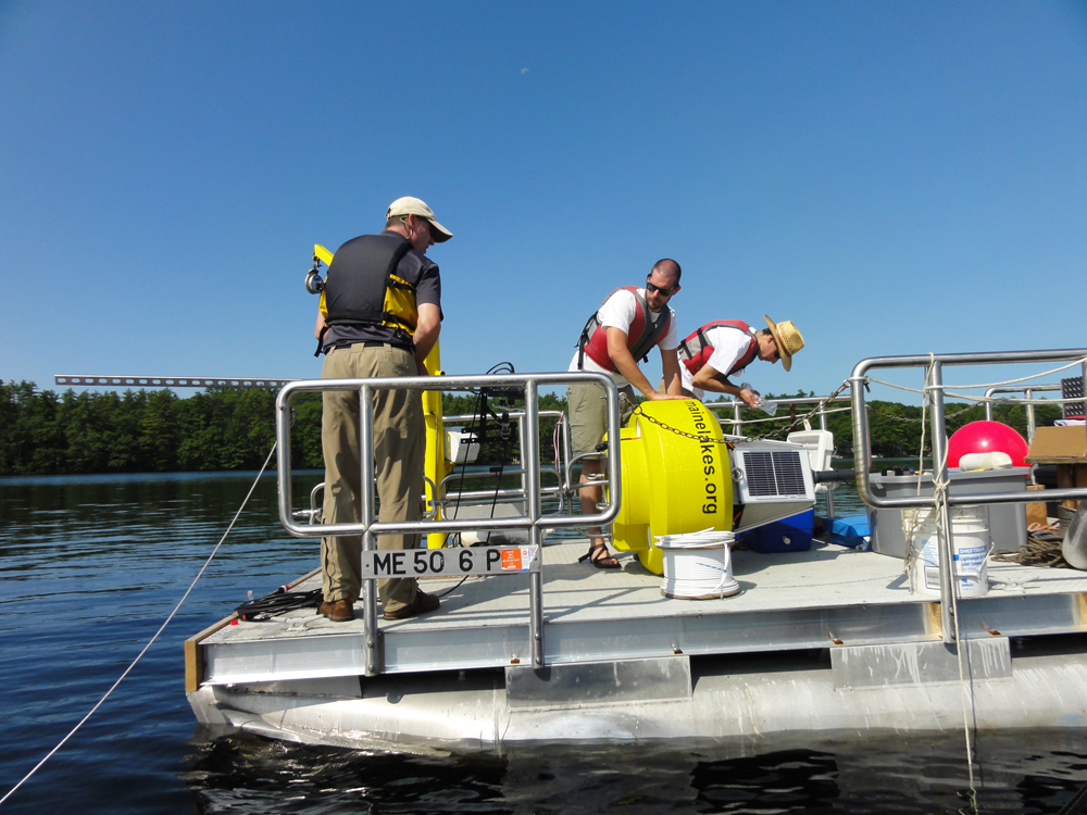 Nate Whalen, Portland Water District, and Adam Perron and Colin Holme, Lakes Environmental Association, launch the Highland Lake buoy on July 18. (Credit: Lakes Environmental Association)