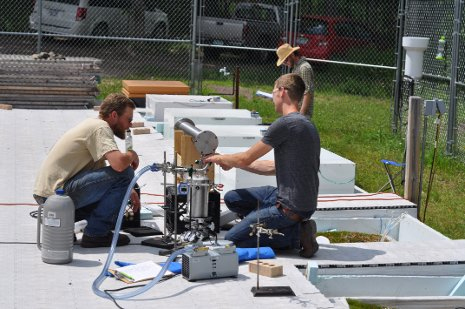 Evan Kane, left, works on a peatcosm with one of his fellow researchers. (Credit: Michigan Technological University)