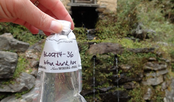 A collected water sample, with its source in the background. (Credit: Kirsten Nicholson)