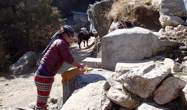 Sherpa woman washing cloths using a town water supply near Lausasa township. (Credit: Kirsten Nicholson)