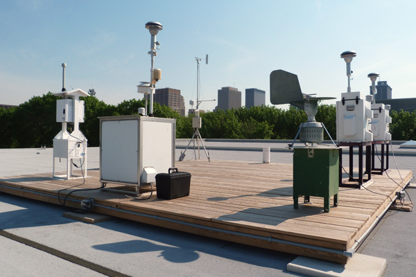 An air quality monitoring platform managed by the Regional Air Pollution Control Agency sits on the roof of a Sinclair Community College maintenance building in Dayton, Ohio. The station is part of the Ohio EPA’s air monitoring network and includes sensors to track ozone, particulate matter, pollen and mold. A weather station, tipping bucket rain gauge and solar radiation sensor also collect meteorological data. (Credit: Daniel Kelly)
