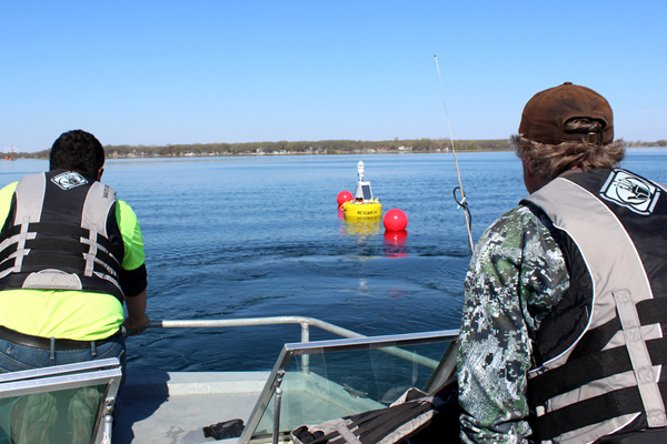 Members of the Iowa Lakeside Laboratory help deploy a new data buoy in West Okoboji Lake. (Credit: Doug Nguyen / NexSens Technology)