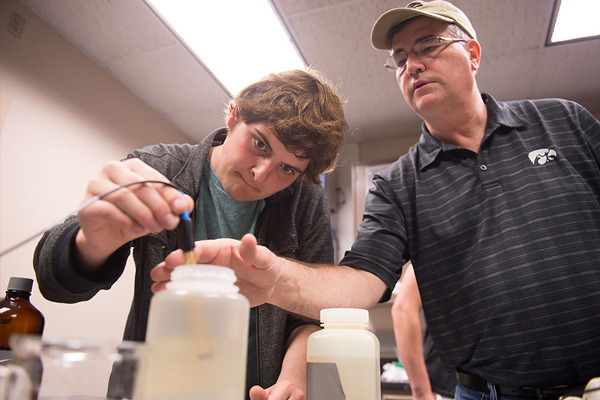 LACMRERS director Doug Schnoebelen helps Austin Hummel use a spectrophotometer to test his river water sample for nitrates. (Credit: University of Iowa)
