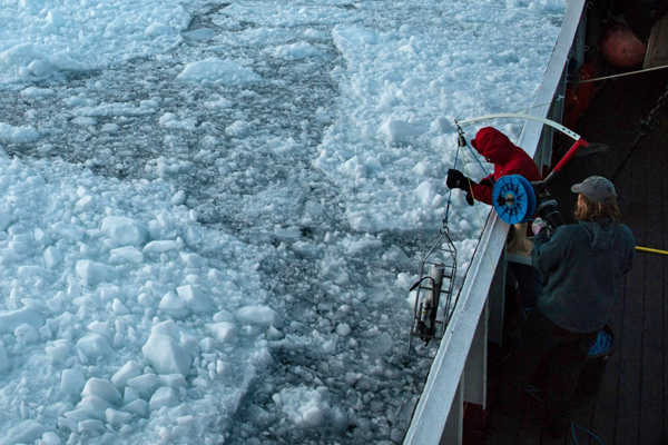 Researchers race to retrieve equipment as sloughed-off glacial ice threatens to trap their boat. (Credit: University of California, Irvine)
