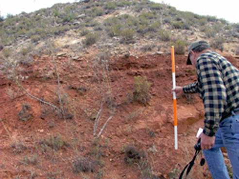 A geologist samples some of the old rocks in Southwest Kansas. (Credit: Kansas Geological Survey)