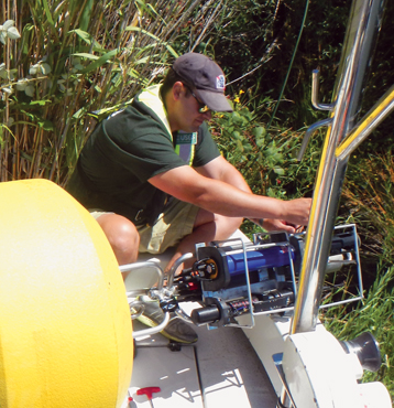 Researcher checks water quality sondes attached to data buoy.