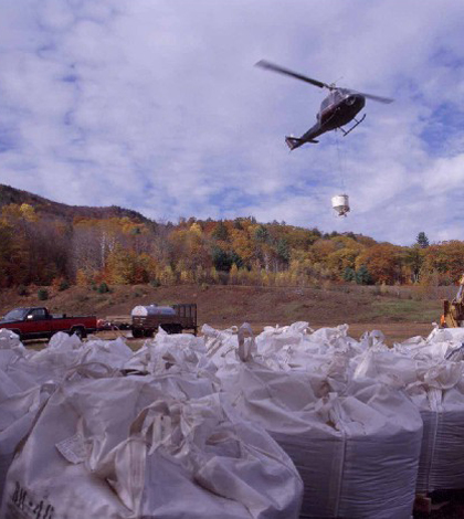 A helicopter loaded with calcium fertilzer pellets takes off over the Hubbard Brook Experimental Forest (Credit: Hubbard Brook Ecosystem Study)