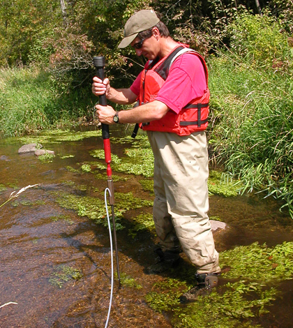 Jim Tesoriero installs a piezometer to sample groundwater in the Tomorrow River streambed. (Credit: USGS)