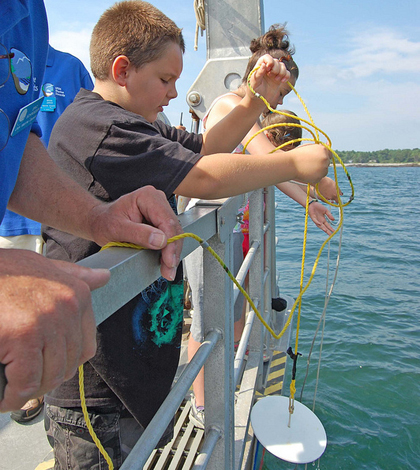 Students learn about secchi disks on a New Hampshire Sea Grant Discovery Cruise (Credit: New Hampshire Sea Grant, via Flickr)