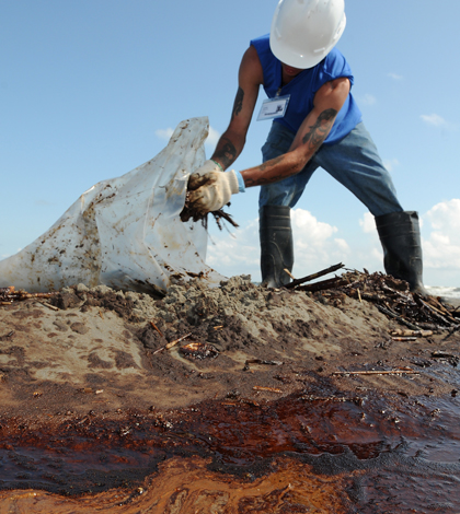 Worker cleans up debris from the Deepwater Horizon oil spill (Credit: Patrick Kelley, Wikimedia Commons)