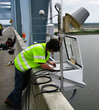 A CO-OPS employee installs an air gap sensor which measures bridge clearance on the Don Holt Bridge in for the NOAA PORTS system inCharleston, S.C. (Credit: NOAA)