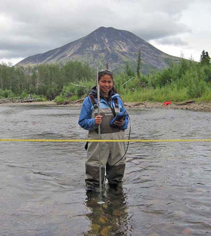 Kristy Wise takes a flow measurement on the Holokuk River (Credit: Dave Cannon)