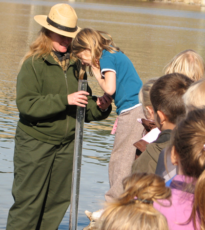 Students from Davenport Elementary School peer into a turbidity tube. (Credit: National Park Service)