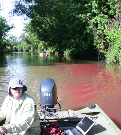 Monitoring boat in the channel of Ninemile Creek, downstream of the dye release location. (Credit: Upstate Freshwater Institute)