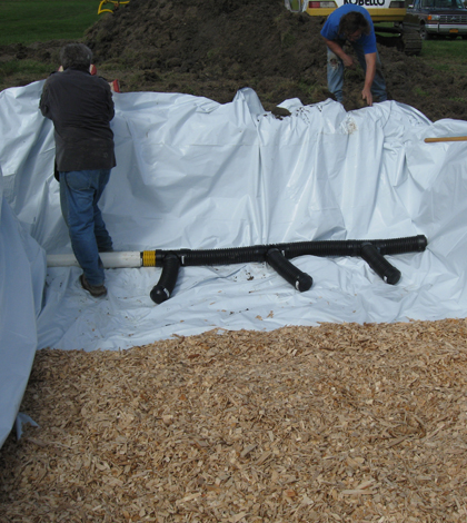Filling a bioreactor with wood chips on a vegetable farm in Freeville, N.Y. (Credit: William Pluer and Larry Geohring)