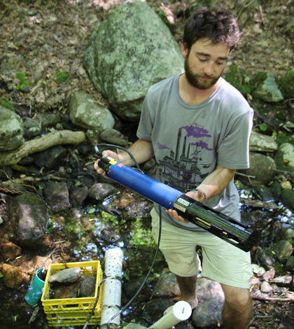 UNH’s Water Resources Research Center lab technician Chris Cook checks aquatic sensor for debris. (Credit: Evelyn Jones)