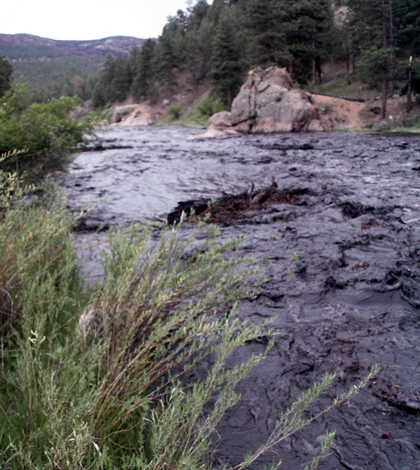 The South Platte River runs black with ash and sediment from runoff from the Hayman fire burn scar 2003 (Credit: Michael Stevens/USGS)