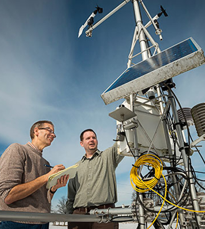 Inspecting a Delaware Environmental Observing System weather station. (Credit: University of Delaware)