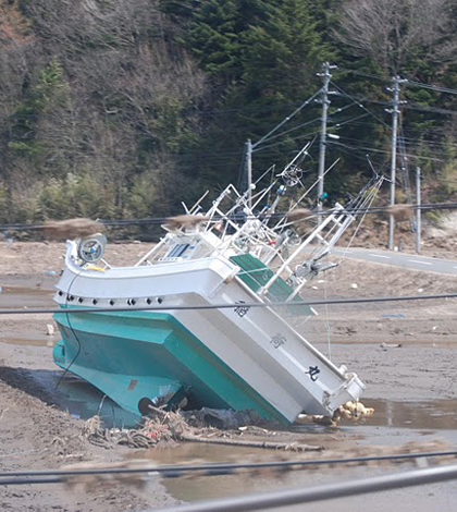 A boat carried inland a month ago by the tsunami still sits in a field, Namie, Fukushima Pref., Japan, April 12 2011 (Credit: S. L. Herman/Voice of America, via Wikimedia Commons)