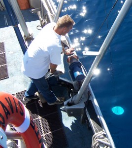 Tahoe Environmental Research Center boat captain Brant Allen conducting a Secchi depth measurement (Credit: Geoff Schladow)