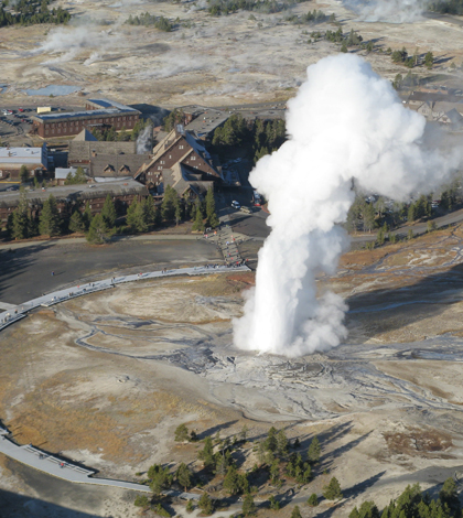 Old Faithful erupts a few hundred yards from the Old Faithful Inn (Credit: Cheryl Jaworowski/National Park Service)