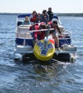 A crew launches "Goldie," the Great Pond data buoy (Credit: Colby College)