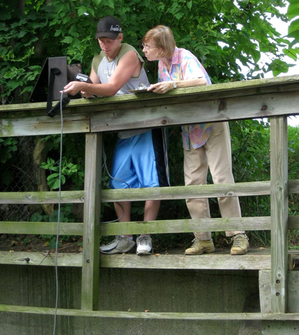 Volunteers with the Huron River Watershed Council measure water quality with a handheld meter. (Credit: Huron River Watershed Council)