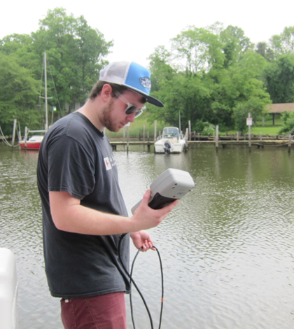 A student samples Mill Creek (Courtesy of Sally Hornor)