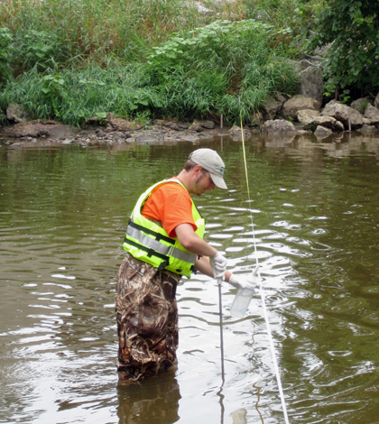 Pete Lenaker of the USGS collects a water sample from the Manitowoc River near Manitowoc, WI. (Credit: USGS)