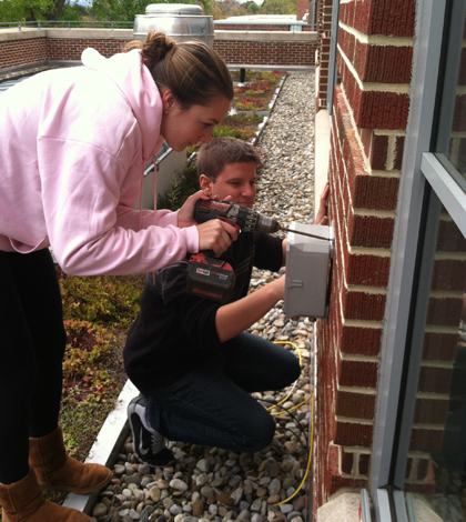 Muhlenberg College students install a junction box for the green roof monitoring system. (Credit: David Rabold)