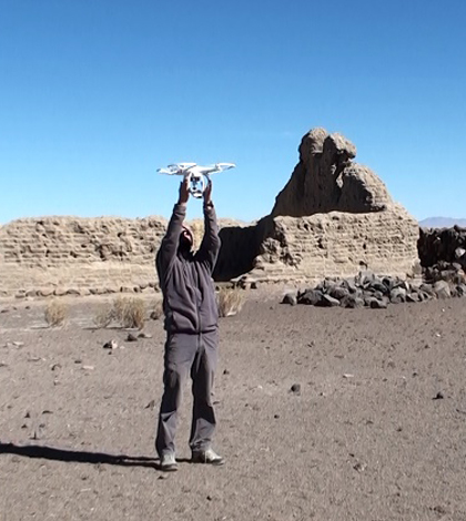 A researcher holds the drone in the middle of a survey area. (Credit: César Parcero-Oubiña)