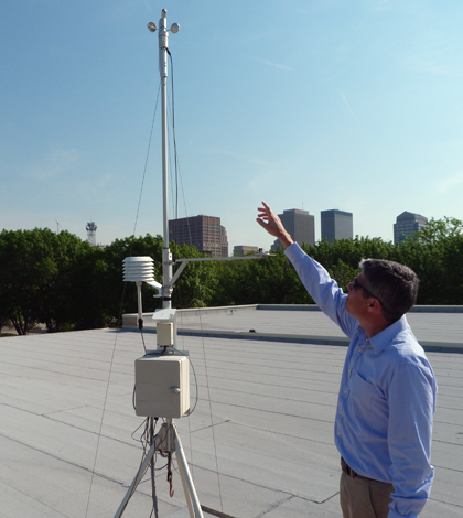 Brian Huxtable, an air pollution control specialist with the Regional Air Pollution Control Agency of Dayton, Ohio, inspects a weather station. (Credit: Daniel Kelly)