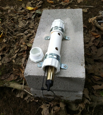 A Solinst Barologger Edge Barometric Pressure Logger is mounted on a cinder block. (Credit: Jessica Schuster)