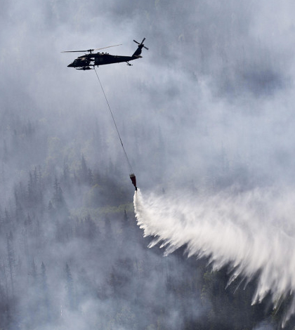 An Alaskan Army National Guard helicopter drops water on a wildfire. (Credit: Sgt. Balinda O'Neal / U.S. Army National Guard)