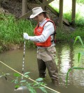 A USGS scientist samples a stream for neonicotinoid concentrations as part of the first national-scale investigation of these insecticides. (Credit: Hank Johnson / USGS)