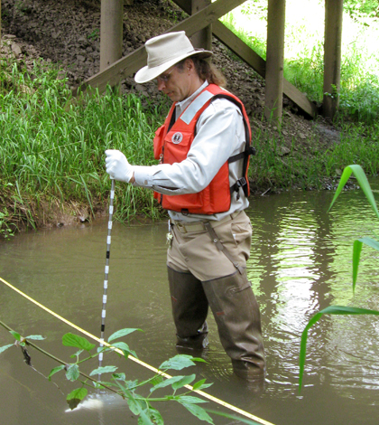 A USGS scientist samples a stream for neonicotinoid concentrations as part of the first national-scale investigation of these insecticides. (Credit: Hank Johnson / USGS)