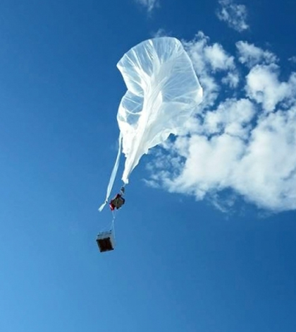 A large plastic research balloon launched by the Montana Space Grant goes up into the sky. (Credit: Berk Knighton / BOREALIS)