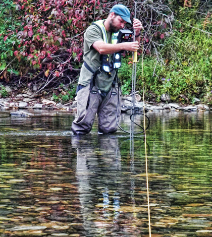 A hydrologic technician from the USGS Idaho Water Science Center measures streamflow in the St. Joe River at Red Ives Ranger Station in northern Idaho. (Credit: Dan Hess / U.S. Geological Survey)