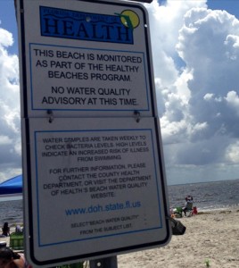 A posted sign about the Florida Healthy Beaches Program. (Credit: Lottie Watts / WUSF)