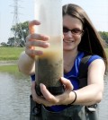 Silvia Newell holds up a sediment core pulled from the upstream side of a dam on the Lower Great Miami River. (Credit: Nate Christopher / Fondriest Environmental)