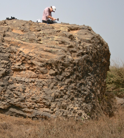 Katherine Adena, a doctoral student at Bristol, samples the top of a stranded boulder for cosmogenic exposure dating. (Credit: Ricardo Ramalho)