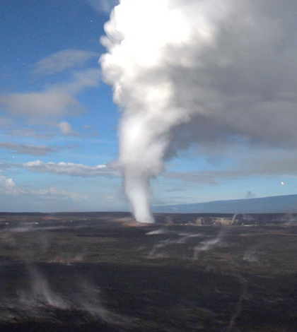 A gas and particle-rich plume emanates from molten lava beneath Halemaumau Crater on the Island of Hawaii. The plume reacts and converts in the atmosphere, forming the acidic volcanic pollution locally known as “vog.” (Credit: Michael Poland / U.S. Geological Survey)